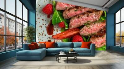 Aerial perspective of a contemporary design plate featuring traditional fried dry-aged bison beef rump steak slices accompanied by vegetables, lettuce, and raspberry dressing. Wall mural