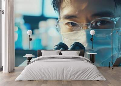 Asian man with face mask using microscope in laboratory for medical research and biotechnology Scientific investigation DNA testing and innovation in microbiology Wall mural