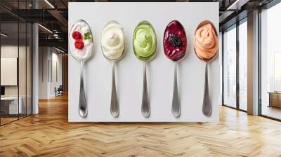 Assortment of tasty yogurts on white background displayed in spoons Wall mural