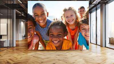 Diverse group of children happily enjoy summer vacation at the beach. Wall mural