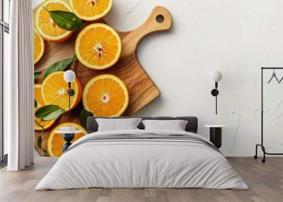 Fresh orange slices on wooden chopping board with empty space white background Wall mural