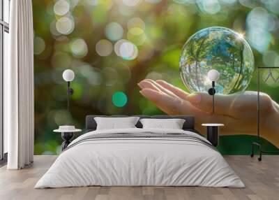 Global Environmental Idea Crystal globe held in human hand with green and blue bokeh Wall mural