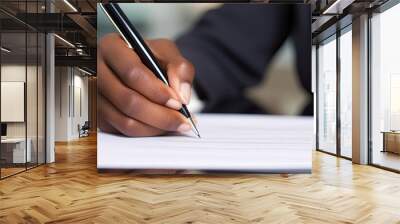 Macro close-up of African American businesswoman's hand signing contract with pen. Wall mural