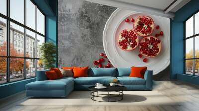 Pomegranate seeds and slices on white plate Wall mural