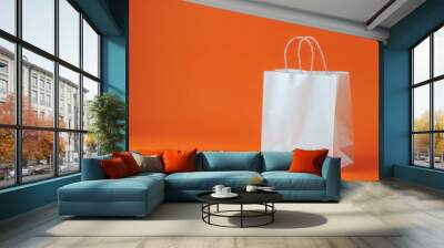 Side view of white shopping bag on orange paper background Wall mural