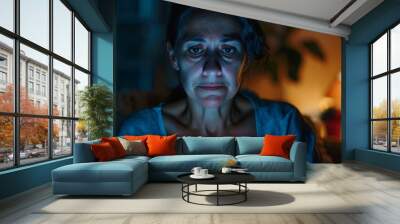 Skeptical, nervous middle-aged Hispanic woman using touchpad at night, upset and frowning over a problem. Wall mural