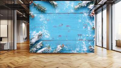 Winter Christmas background featuring fir branches pine cones and snow on a blue wooden surface Wall mural