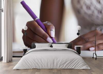 Women writing with a purple pen on a blank notebook Wall mural