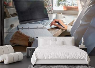 Close up shot, young businesswoman using laptop in coffee shop, crop image of manager busy working with pc, female hands typing on computer keyboard sitting at cafe wooden desk, work process concept Wall mural