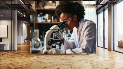 African American young scientists conducting research investigations in a medical laboratory, a researcher in the foreground is using a microscope Wall mural