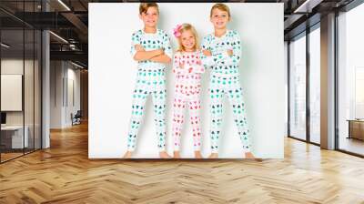 Holiday family pajamas portrait with three siblings shoulder to shoulder Wall mural