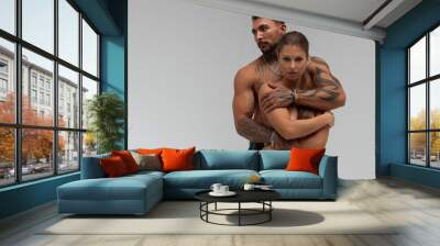 Muscular man hugging topless woman Wall mural