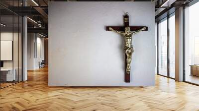 a cross hung on a white wall Wall mural