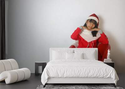 a cute little girl wearing a santa claus hat isolated on white background Wall mural