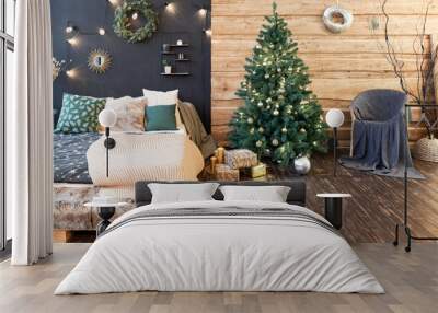 On the eve of the holiday, the interior of the country house is decorated with a New Year tree. large spacious light room decorated with wood with simple wood furniture Wall mural