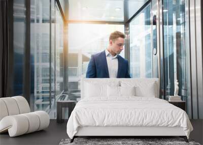 Businessman in elevator in the office center Wall mural