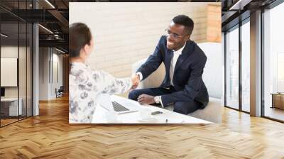 Close up of African American man shaking hand with his his female colleague Wall mural