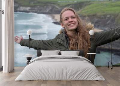 Young and happy woman smiles at the camera Wall mural