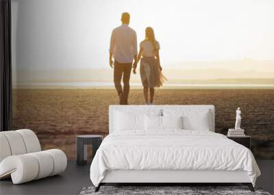 Couple in love walking on the beach and looking at each other Wall mural