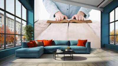 hands praying with a bible over wooden table Wall mural