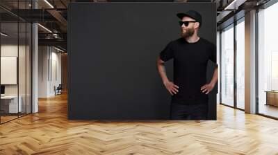 Hipster handsome male model with beard wearing black blank t-shirt with space for your logo or design in casual urban style wth copy space Wall mural