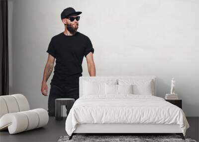 Hipster handsome male model with beard wearing black blank t-shirt with space for your logo or design in casual urban style Wall mural