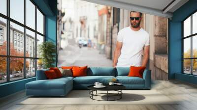 Hipster handsome male model with beard wearing white blank t-shirt with space for your logo or design in casual urban style Wall mural