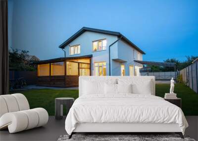 Modern minimalist white color house exterior in the evening with garden, lawn and patio area in summer time Wall mural