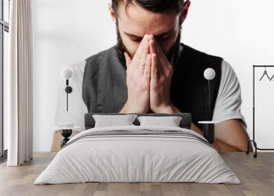 Young man praying over grey background Wall mural