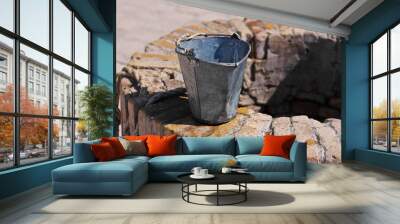 A water well with an old bucket Wall mural