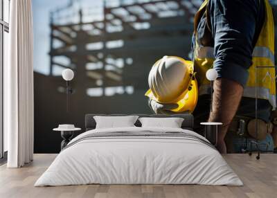 Construction worker holding his helmet while looking at construction site. Occupational Safety and Health (OSH)  Wall mural