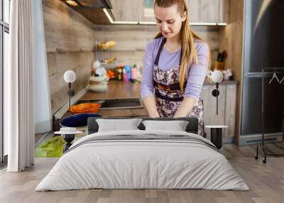 Caucasian female making food in a kitchen Wall mural