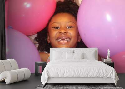 Adorable African American Child Smiling surrounded by Pink and Purple Balloons Wall mural