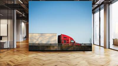 Semi truck on highway at sunset red tractor with blue sky Wall mural