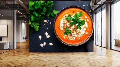 Autumn pumpkin soup puree with pumpkin seeds, cream, pepper and parsley. Winter healthy vegan slow comfort food. Soup bowl on black table background. Top view Wall mural