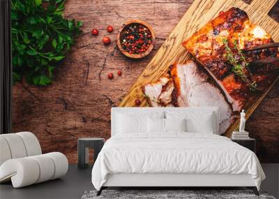 Baked festive pork butt or ham with herbs, spices and cranberries for sauce, served and sliced on cutting board, rustic wooden table background, top view Wall mural