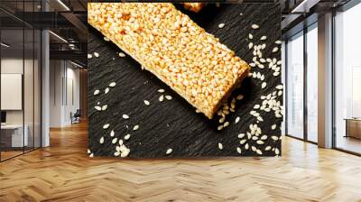 bar of sesame seeds in honey and scattered grain on dark stone b Wall mural