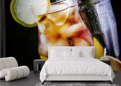 Cold cocktail with cola, lemon, rum and ice cubes, black backgro Wall mural