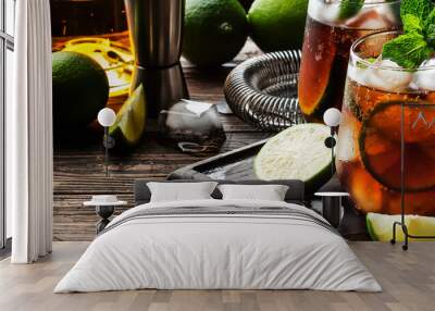 Cuba libre or rum cola cocktail with strong alcohol, lemon juice, lime and ice, dark background, steel bar tools, copy space Wall mural