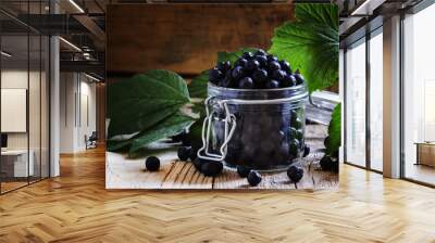 Fresh berries chokeberry in a glass jar, vintage wooden backgrou Wall mural