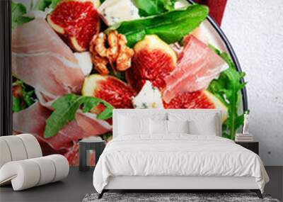 Fresh fig salad with prosciutto, gorgonzola, walnuts, arugula on white kitchen table background, top view, copy space Wall mural