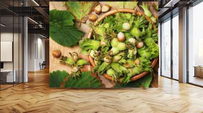 Fresh hazelnuts in shell with leaves in wooden bowl, vintage wooden background, top view Wall mural