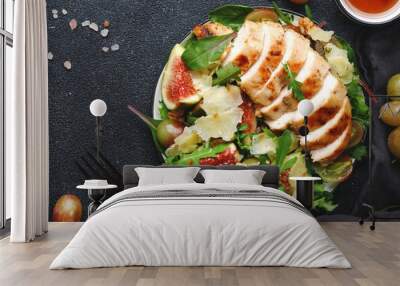 Grilled chicken fillet with fig, grape, arugula and chard salad. Black table background, top view Wall mural