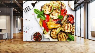 Grilled colorful vegetables, aubergines, zucchini, pepper with spice and green basil on serving board on white background, top view Wall mural