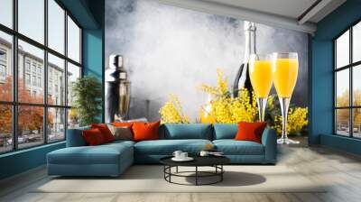 Low alcohol cocktail mimosa with orange juice and cold dry champagne or sparkling wine in glasses, blue background with flowers, place for text, selective focus Wall mural