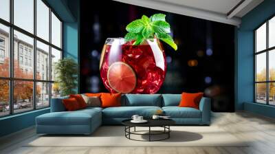 Royal lemonade alcoholic cocktail drink with tequila, dry gin, white rum, vodka, liquor, lime, raspberries and ice in wine glass. Black bar counter background, bar tools and bottles Wall mural