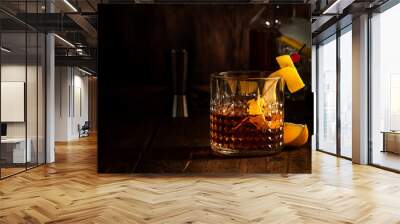 Sazerac cocktail with cognac, bourbon, absinthe, bitters, sugar and lemon zest. Old wooden bar counter background with copy space Wall mural