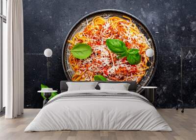 Spaghetti bolognese or pasta with minced meat in tomato sauce with green basil sprinkled with grated parmesan cheese, dark table, top view Wall mural