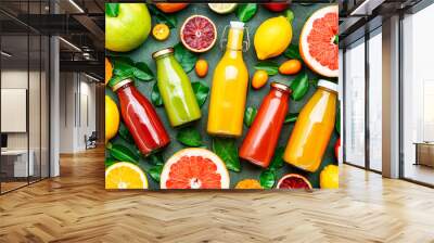 Summer drinks. Citrus fruit juices, fresh and smoothies, food background, top view. Mix of different whole and cut fruits: orange, grapefruit, lime, tangerine with leaves and bottles with drinks Wall mural