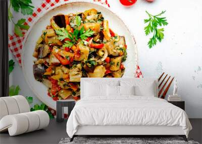 Vegetable stew, saute or caponata. Stewed eggplant with paprika, tomatoes, spices and herbs. White kitchen table background, top view, copy space Wall mural